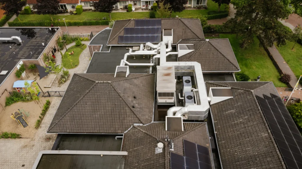 Luchtfoto van een gebouwencomplex met luchtbehandeling en zonnepanelen op het dak