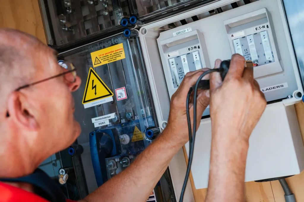 Monteur meet aan een elektrische verdeelkast