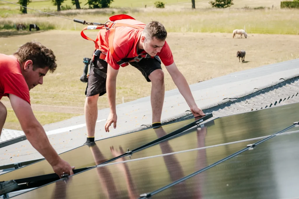 Twee monteurs leggen zonnepanelen op een dak